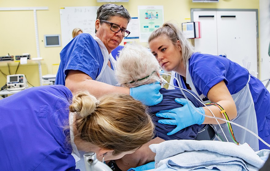 Vårdpersonal hjälper patienten att sitta upp i sängen.