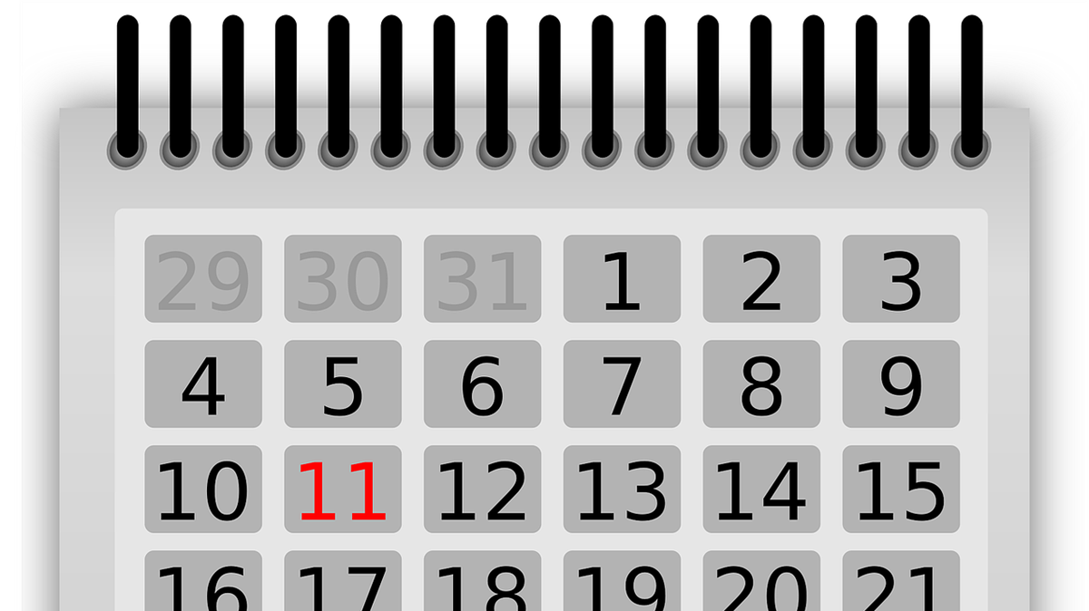 Bild på en kalender med spiralpärm i grått, svart, vitt och rött