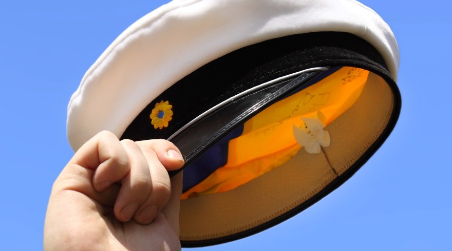 Hand som håller i studentmössa