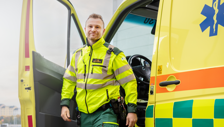 Ambulanssjuksköterska på väg ut ur en parkerad ambulans