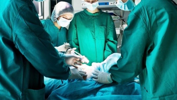 Sjukvårdspersonal står runt patient vid operation.