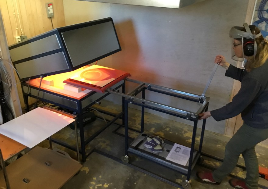 Marie Isaksson drar ut en färdigbränd emaljplåt ur den 800 grader varma ugnen.