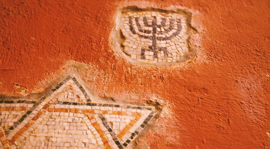 en brandgul vägg med davidsstjärnan och en menora