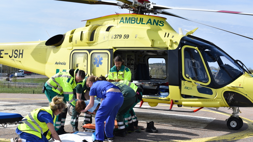 ambulanshelikopter, sjukvårdspersonal och patient.