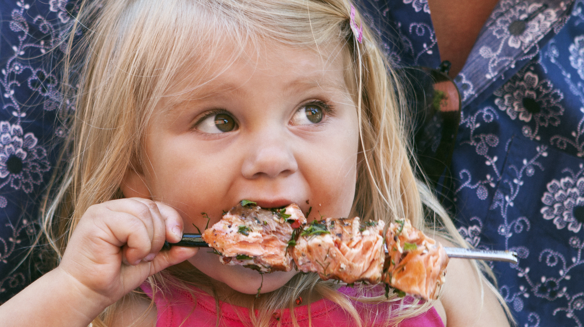 Flicka äter laxspett