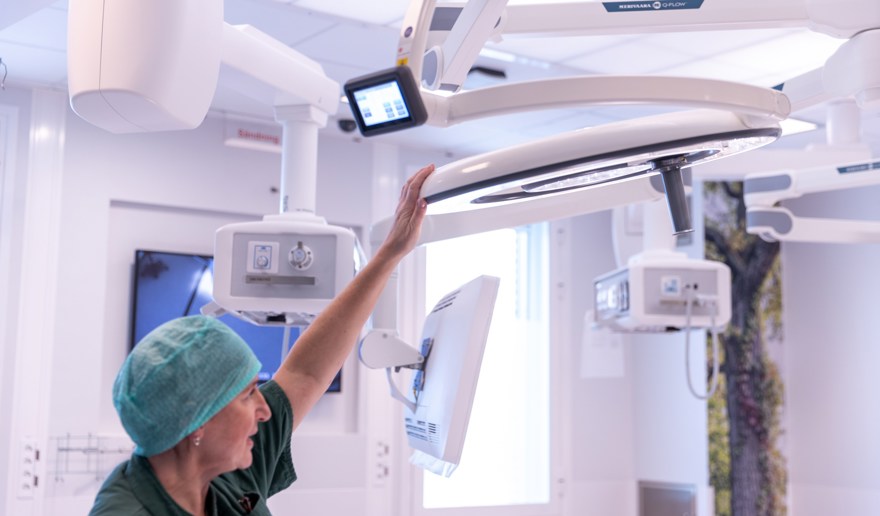 Operationssjuksköterska justerar operationslampan i taket.